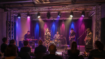 Moving head wash lights creating soft color coverage on a live band stage