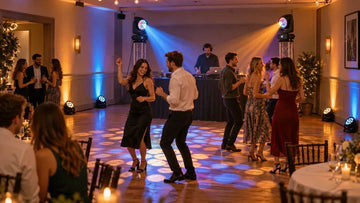 Guests dance beneath blue and amber lights in a reception room with PAR fixtures and moving heads